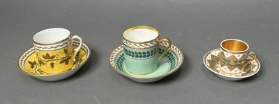 three cups and a saucer sitting on a table