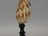 an image of an egg shell on a black stand