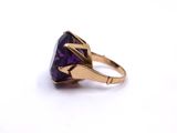a close up of a ring with a purple stone in it