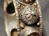 a close up of a silver bracelet with a citrine stone