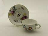une petite tasse et une soucoupe posées sur une table