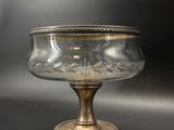 an antique glass bowl with a gold rim on a black surface