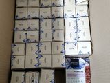 une boîte remplie de paquets de cigarettes posée par terre