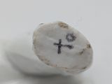 a small rock with a cross on it sitting on a white surface