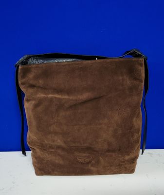 un sac en papier brun posé sur une table blanche, près d'un mur bleu