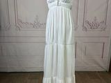 the white dress is on a mannequin stand in front of a wall