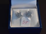 a pair of earrings in a box with a price tag on it