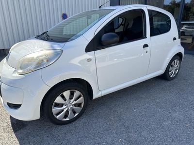 the small white car is parked in front of a building