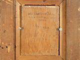 an old picture of a wooden frame with a sign on it