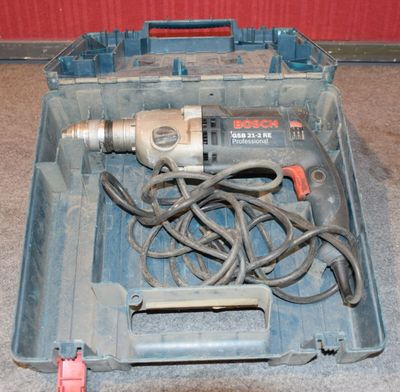 une perceuse dans une boîte à outils, avec un cordon à l'intérieur