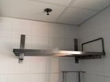 a metal shelf with a shelf on it in a bathroom
