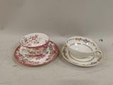 two cups and saucers are sitting side by side on a table