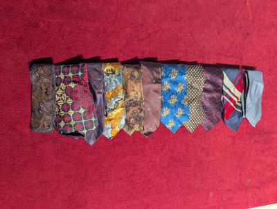 a pile of ties on a red table cloth
