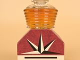 une petite bouteille en verre avec une étiquette rouge et blanche