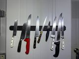 many knives hanging on the wall in the kitchen