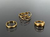 three gold rings sitting on top of a table next to each other