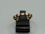 une image représentant une bague en or posée sur un socle noir