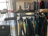 a room with a rack of clothes and a chair