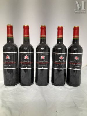 four bottles of red wine are lined up on a table