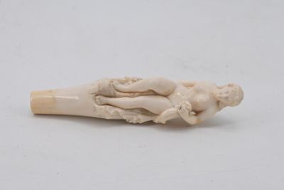 an ivory figurine of a woman holding a child on her lap