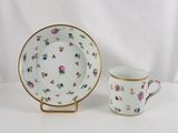 an image of a cup and saucer sitting next to each other