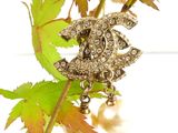 a pearl and diamond brooch on a branch of a tree