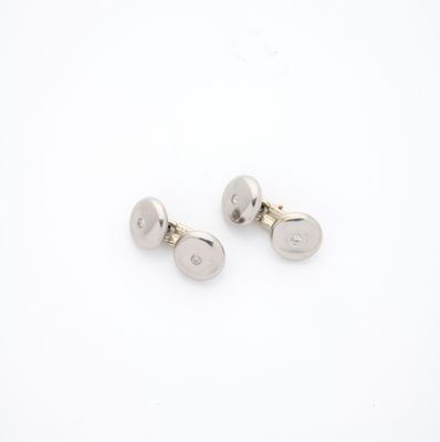 une paire de boutons de manchette plaqués argent sur fond blanc