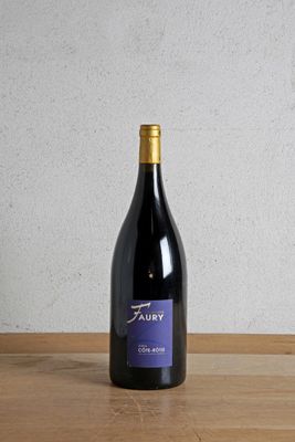 a bottle of wine sitting on top of a wooden table