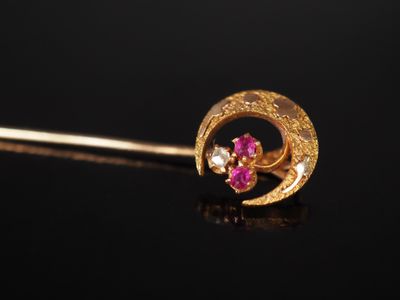 un gros plan sur un piercing au nez en or orné de pierres roses et blanches