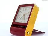 une horloge rouge et dorée posée sur une table