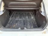 a trunk of a car with a black floor mat in it