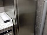 a stainless steel refrigerator in the corner of a kitchen