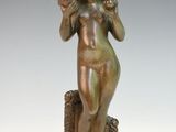 an image of a bronze statue of a woman sitting on top of a tree stump