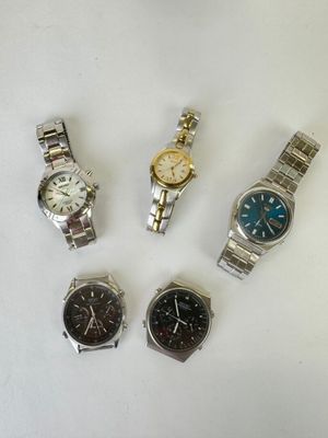 four watches are sitting on a white surface with a white background