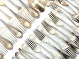 a lot of silver spoons and forks laid out on a table