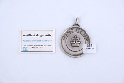a close up of a medal on a white surface with a tag