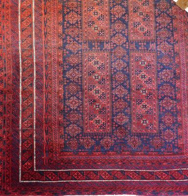 Tapis à fond rouge. 1m70 x 2,54 m (usures, décoloration)