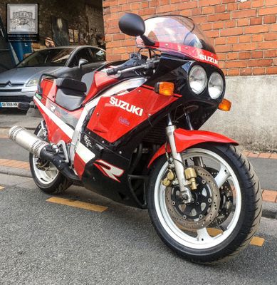 a red and black motorcycle parked on the side of the street