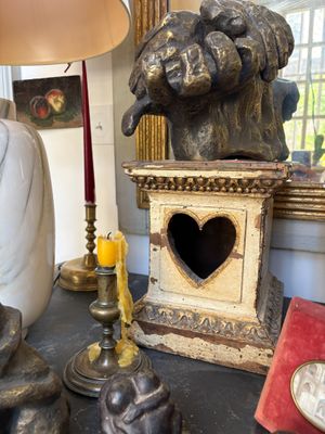 a statue of a man holding a heart on a table
