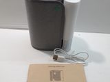 a black and white speaker sitting on a table next to a brown box