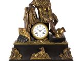 une statue d'un homme assis au sommet d'une horloge