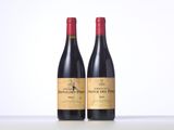 two bottles of red wine sitting on top of a table