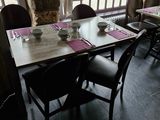 une salle à manger avec une table et des chaises, ainsi qu'une grande fenêtre