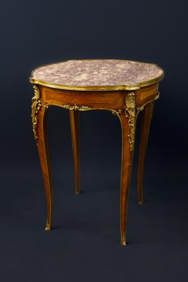 une petite table avec un plateau en marbre sur fond noir