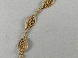 a close up of a gold bracelet with a chain