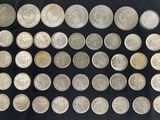 a large collection of silver coins on a black background