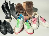 Plusieurs paires de chaussures sont alignées sur une table à côté d'un ours en peluche