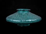 un vase en verre posé sur une surface noire