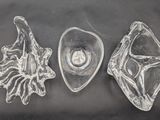 three pieces of glass sitting on a black surface