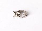 silver ring with a dog on it sitting on a white surface